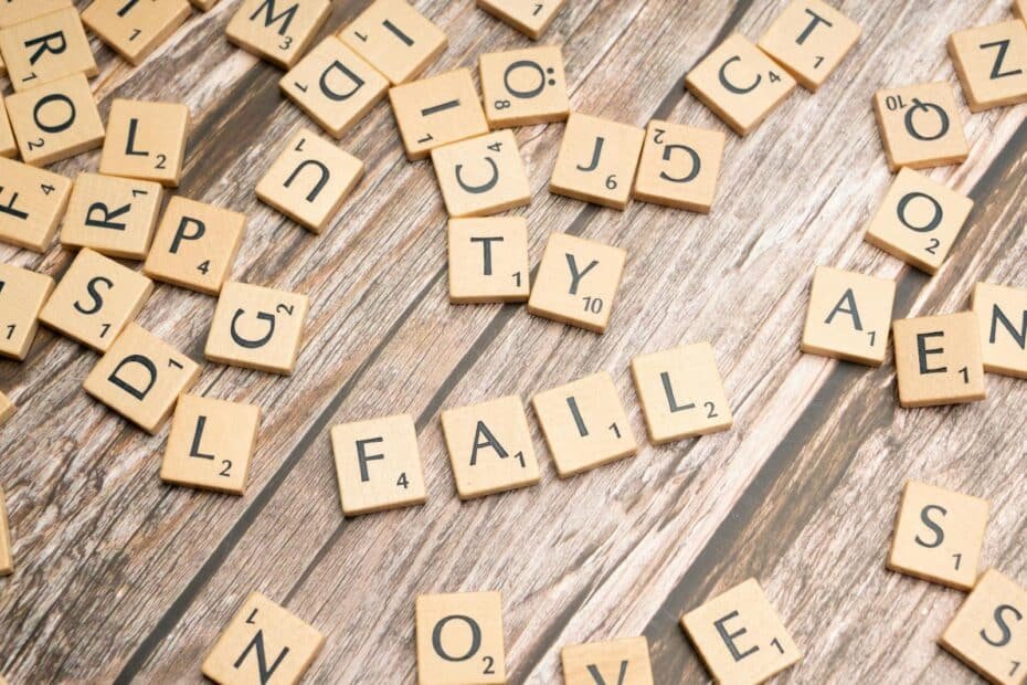 Wooden letter tiles spell fail, symbolizing creativity and setbacks on a rustic surface.