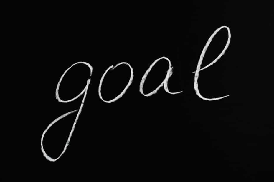 Elegant cursive goal inspires ambition on a striking black background, inviting personal reflection.