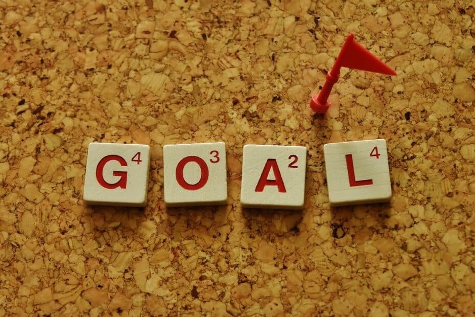 Motivational goal letters on corkboard with playful flag symbolizing achievement and progress.