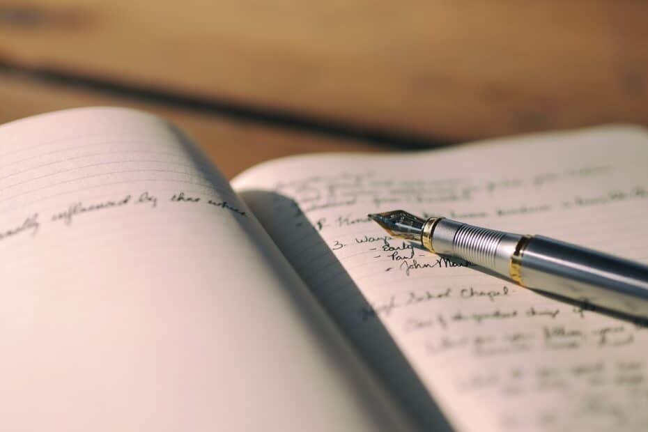 Elegant journaling scene with a fountain pen and handwritten notes on a wooden surface.