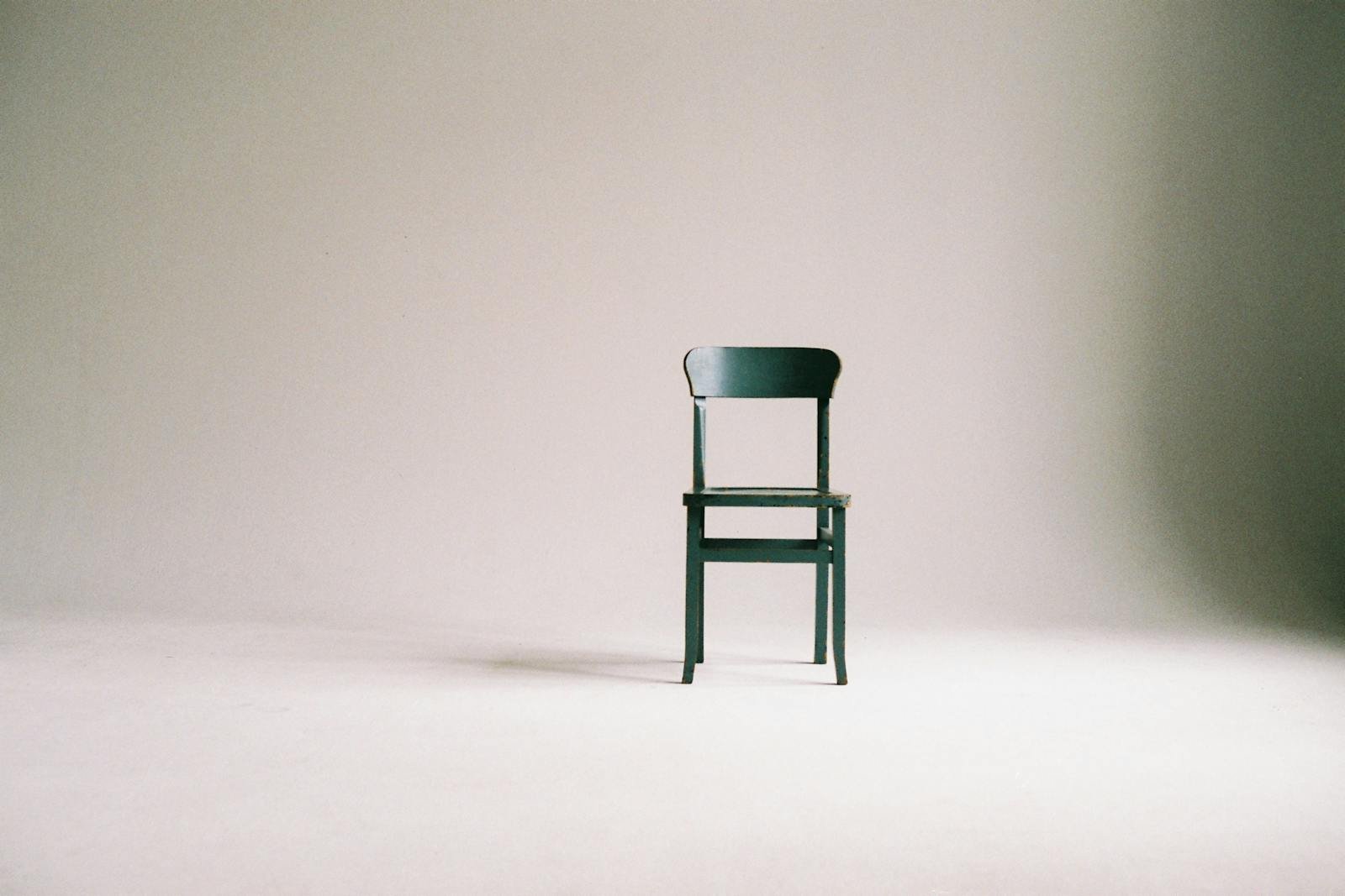 Elegant green chair in minimalist setting invites reflection and tranquility in simple design. - is minimalism bad