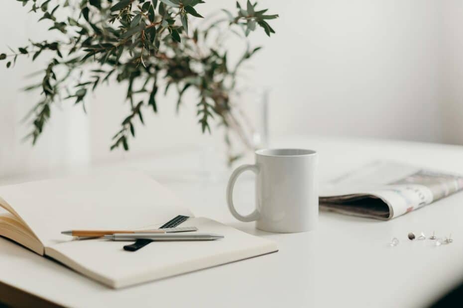 Minimalist workspace with notebook, writing tools, and greenery for creativity and inspiration.