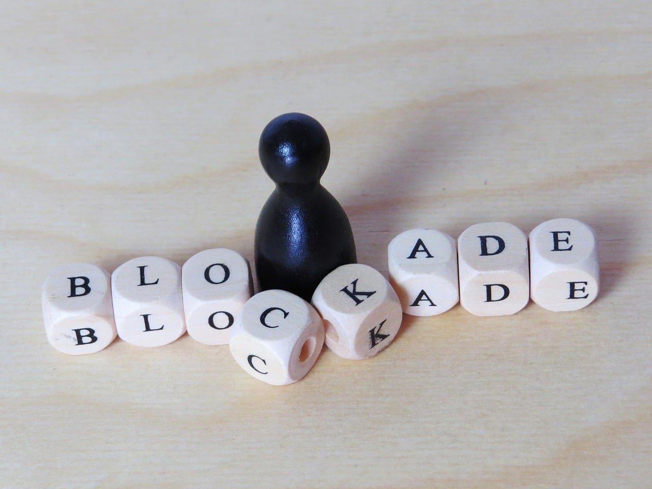 Pawn and blocks symbolize strategy and obstacles in gameplay on a wooden backdrop.