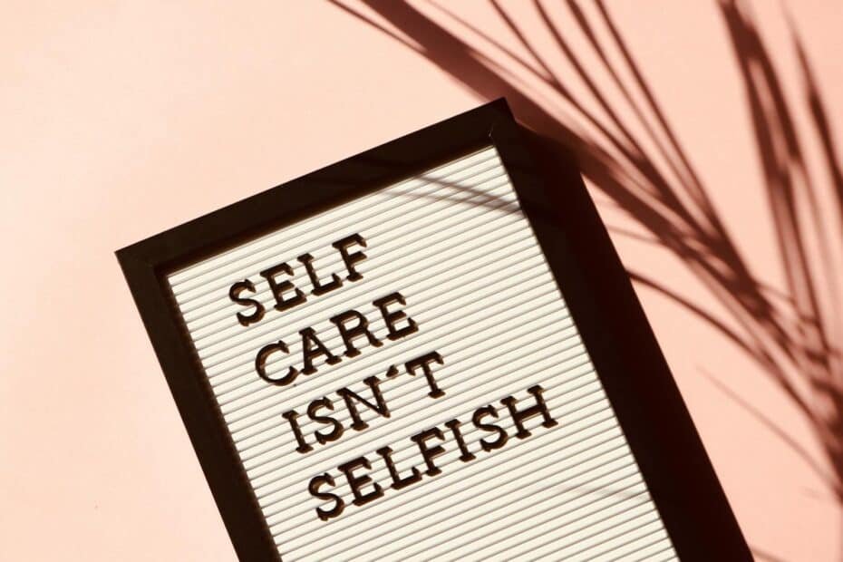 Framed sign: self care isnt selfish on a soothing pink background with leafy accents.