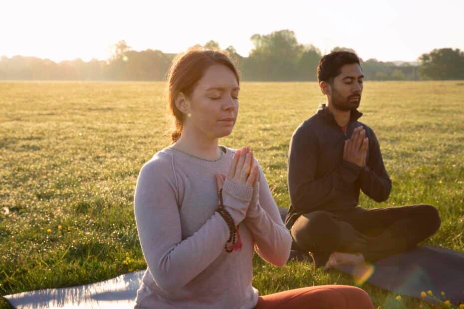 Side view man woman meditating outdoors