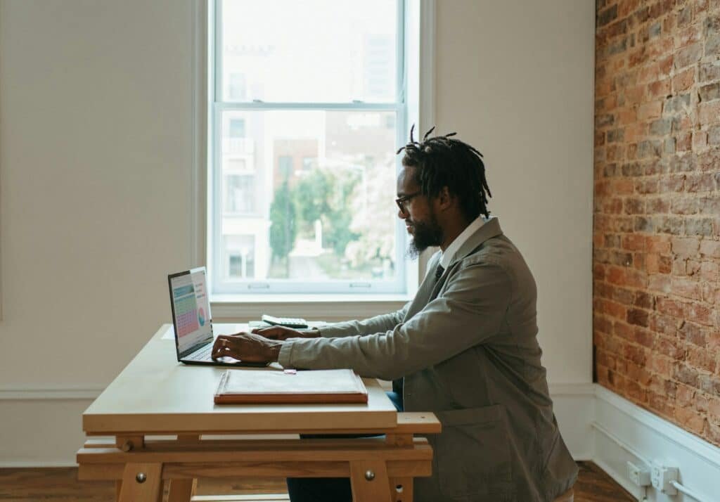 A person sitting at a desk with a laptop and papers