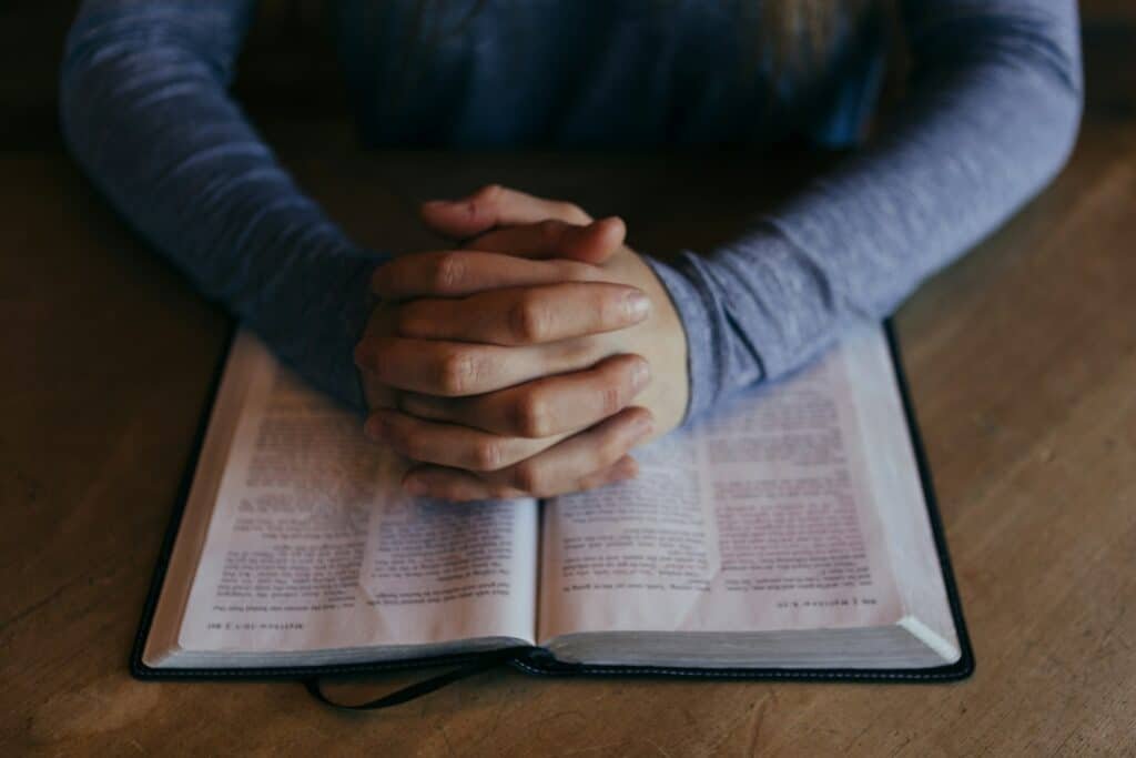 Man holding his hands on open book