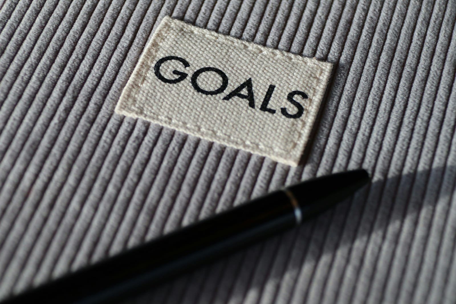 Black and silver pen on gray textile, goal setting 101