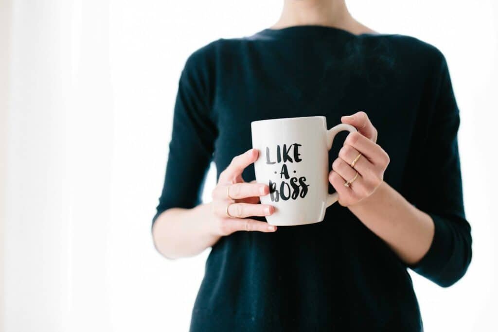 Woman holding white mug while standing