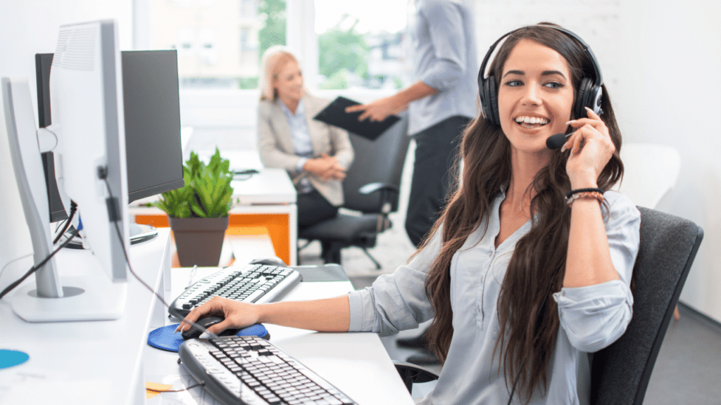 A woman wearing a headset and sitting at a desk