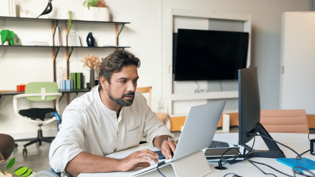 A man sitting at a desk using a laptop