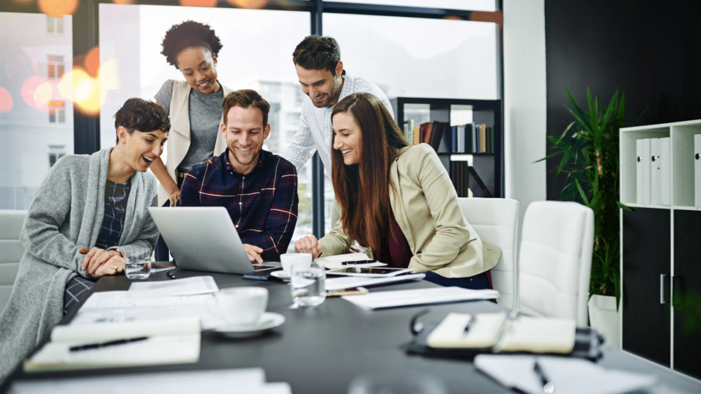 A group of people looking at a laptop