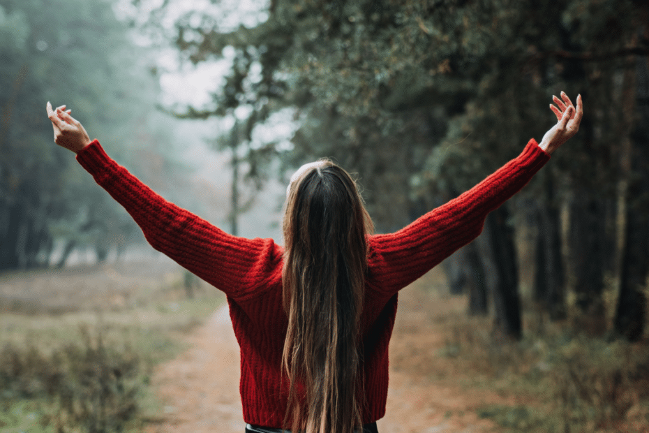 An image of a woman raising both her arms