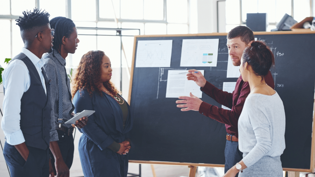A group of people standing around a blackboard
