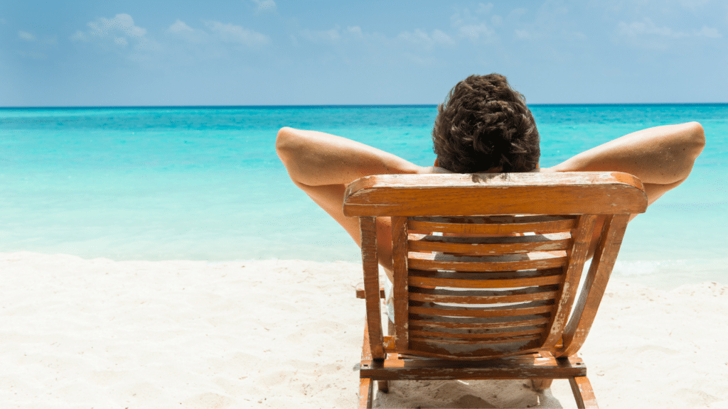A person sitting on a chair at the beach