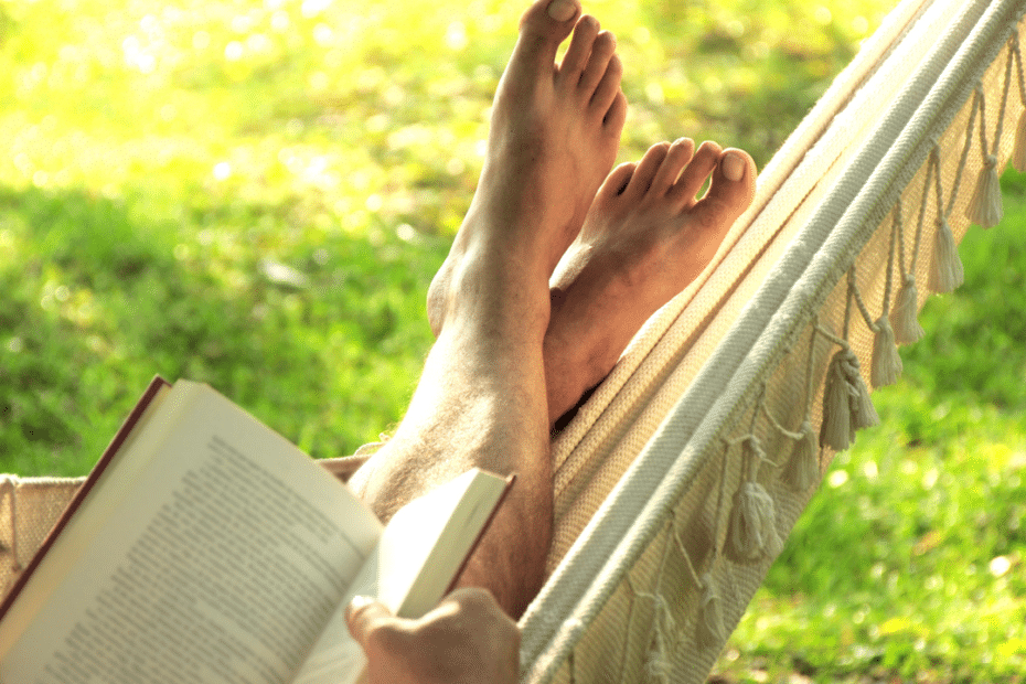 A person reading a book in a hammock
