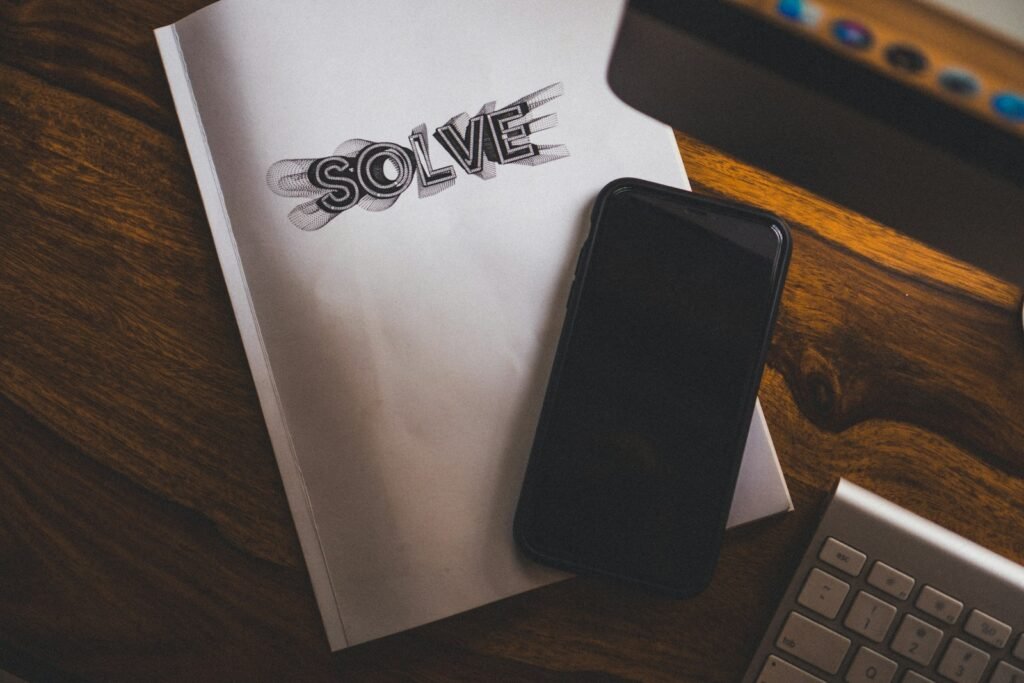 Black phone on top of white notebook